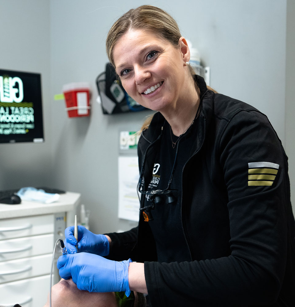 staff member smiling and examining dental patient