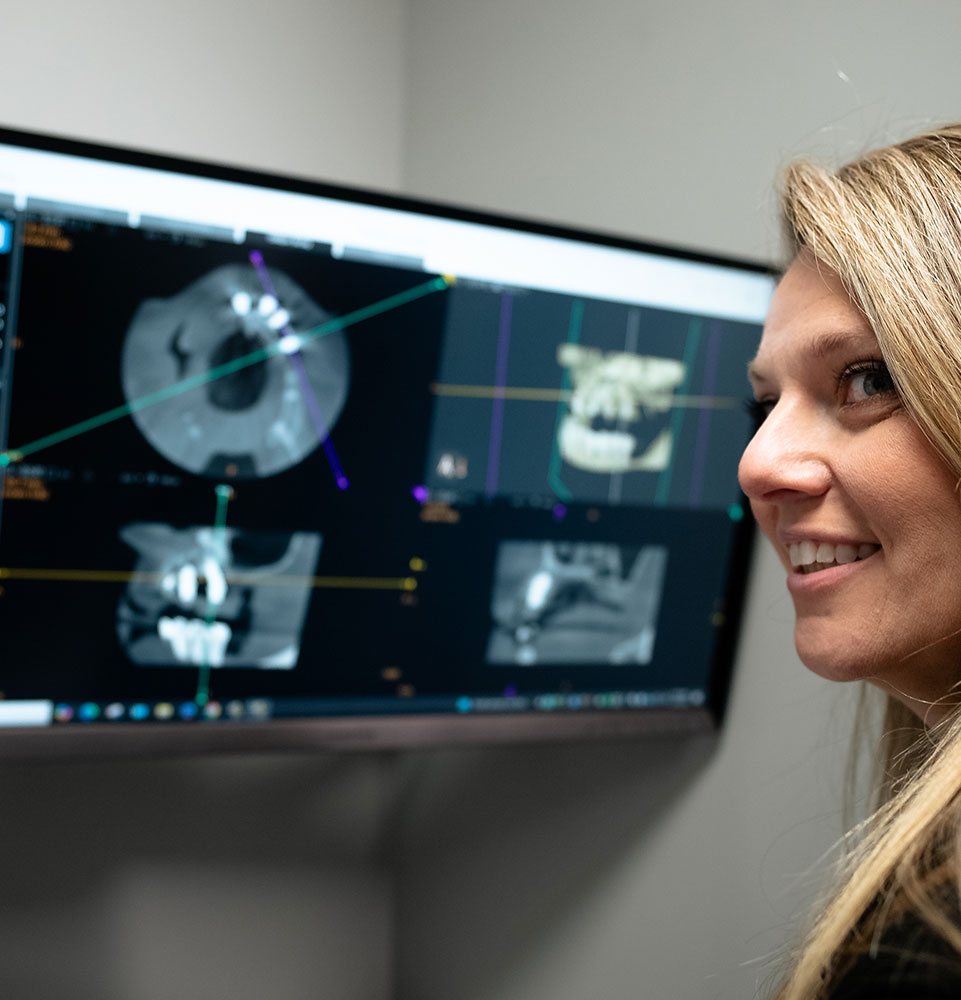 staff member going over dental information on the display device in the dental ab