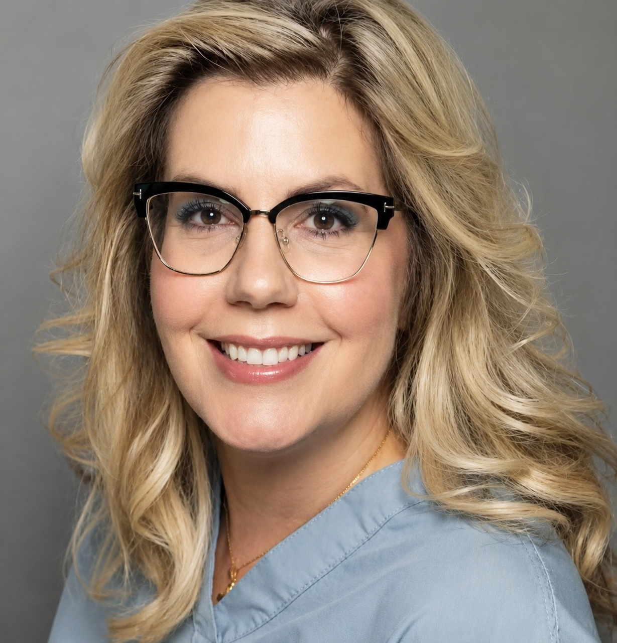 Dr. Lisa Kane smiling in light blue scrubs
